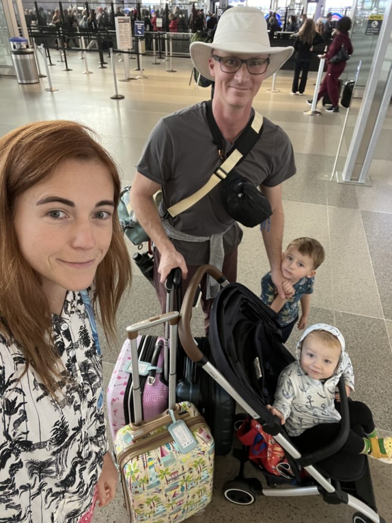 Family with toddler and baby using a travel stroller at the airport