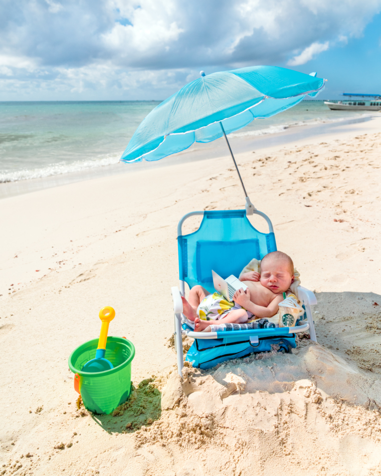 Infant photoshoot in a toddler beach chair with umbrella.