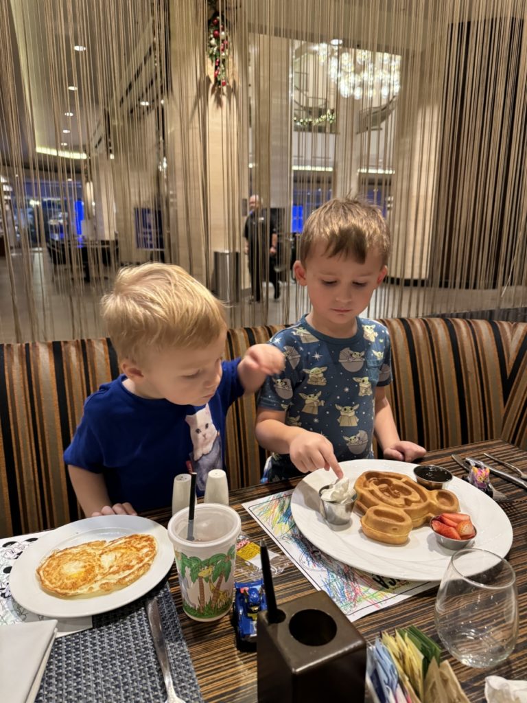 Two little kids eating mickey mouse shaped waffle wearing baby yoda disney themed bamboo shirt