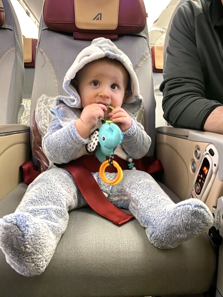 Infant sitting on a plane without a car seat