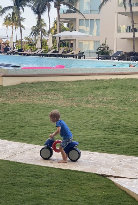 toddler on a ride on two wheeled bicycle