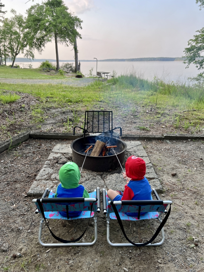 Toddlers camping grilling a sausage